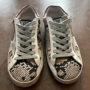 Woman’s Golden Goose snake sneakers.